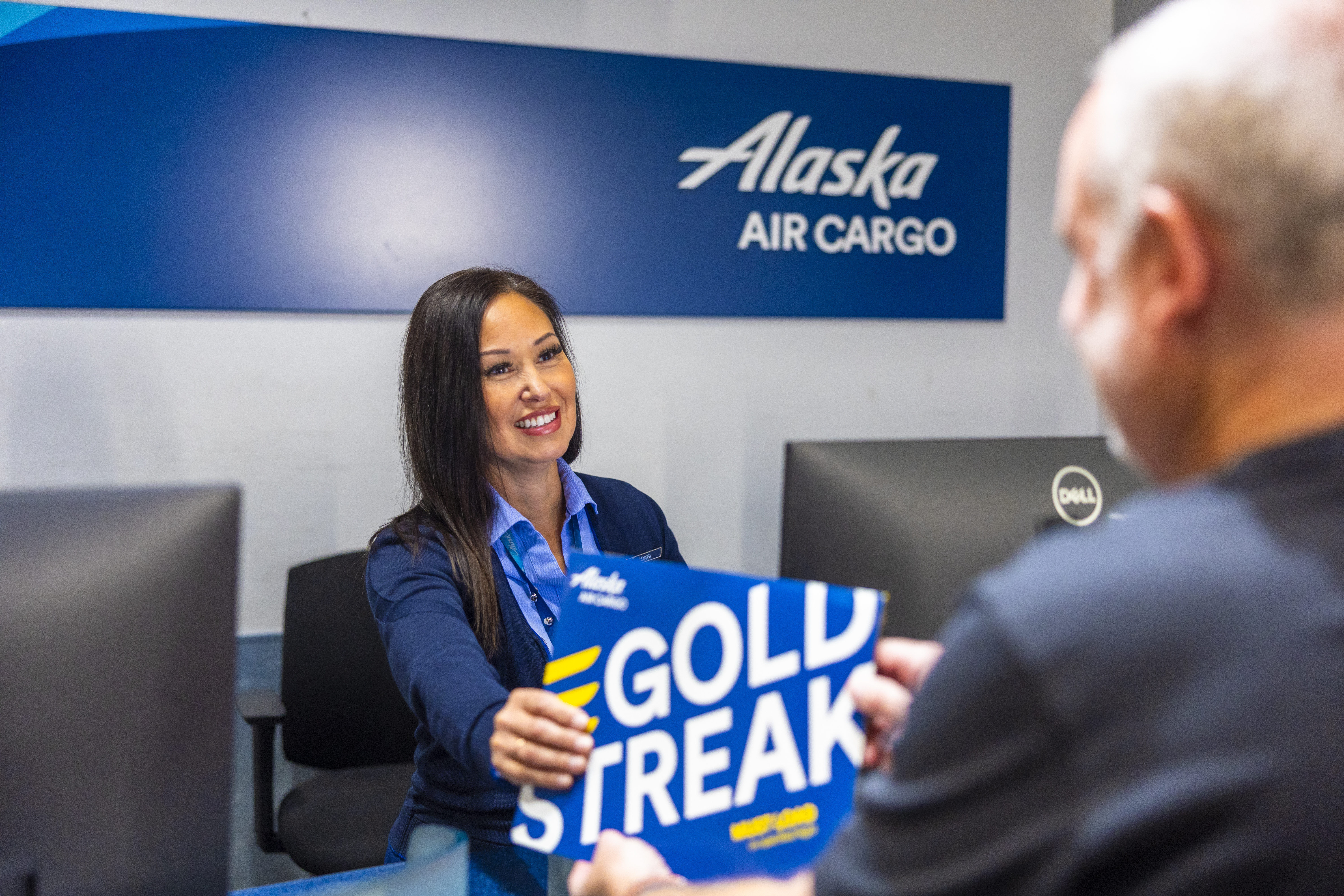 Alaska Air Cargo customer service agent with GoldStreak Express package