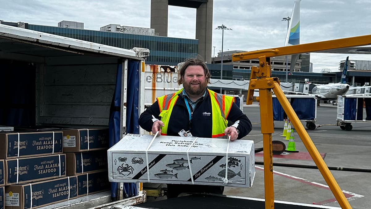 Alaska Airlines manager of station operations in Boston holding box of Copper River salmon